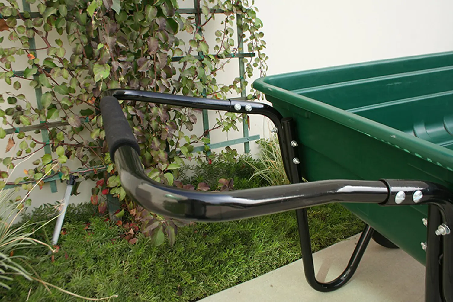 A green cart with a black handle and a green tub.