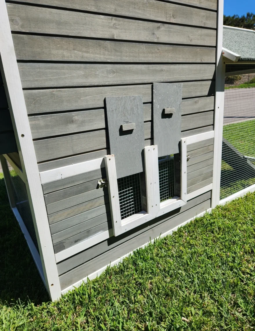 Gray wooden chicken coop with nesting doors