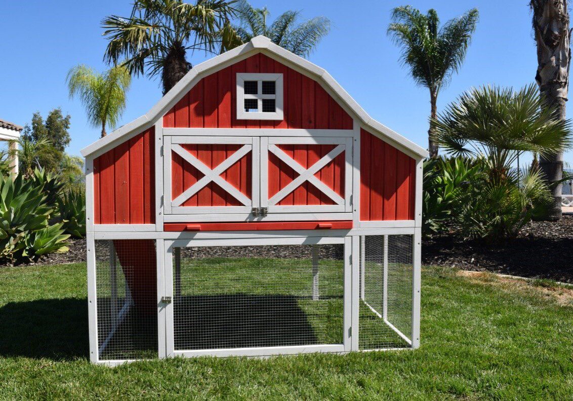 A red barn with a chicken coop in the middle of it.